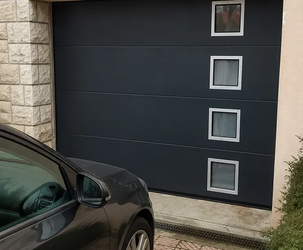 Porte de garage sectionnelle noire en PVC aluminium installée à Normanville